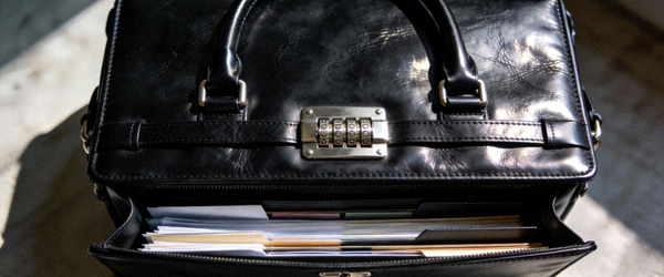 黑色经典皮质公文包实拍，展示双提手、密码锁和内部文件隔层