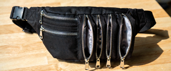 黑色尼龙多功能腰包实拍，展示可拆卸腰带和多个拉链隔层