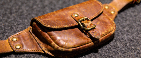 棕色复古皮革腰包高清实拍，展示做旧五金和翻盖搭扣设计