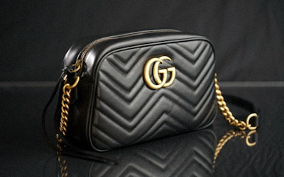 Structured beige tote bag with leather handles and brand logo plaque