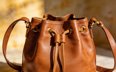 Bucket Style Crossbody Bag in caramel leather with drawstring closure and adjustable strap